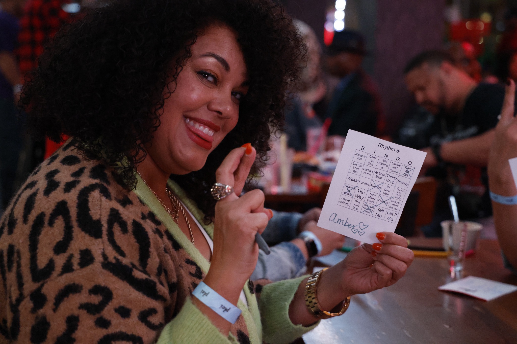Rhythm & Bingo guest smiling and holding her completed music bingo card
